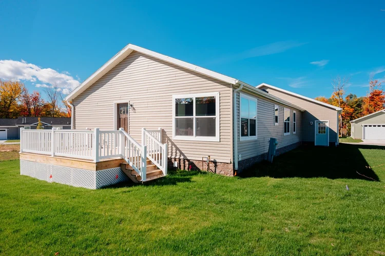 Back of the home with deck and yard