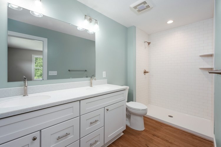 Primary bathroom with double vanity and tiled shower