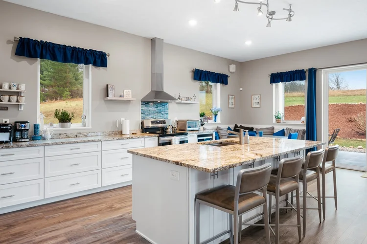 Kitchen with white cabinets and granite island