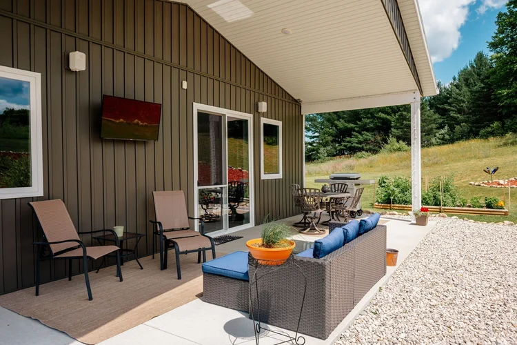 Covered patio with outdoor seating and wall TV