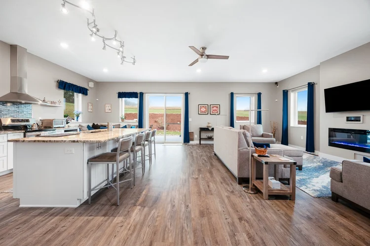 Open kitchen and living area with wood look floors