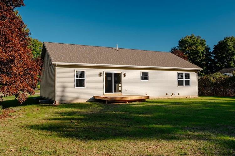 Back of the house with wood deck and lawn