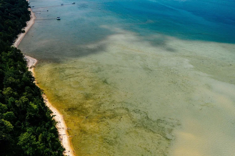 Aerial of sandy shoreline and shallow bay water
