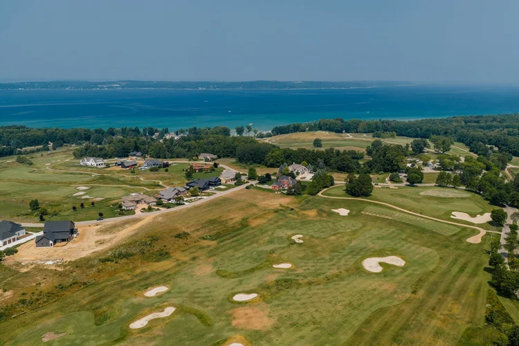 Aerial of golf course fairways, homes and the bay