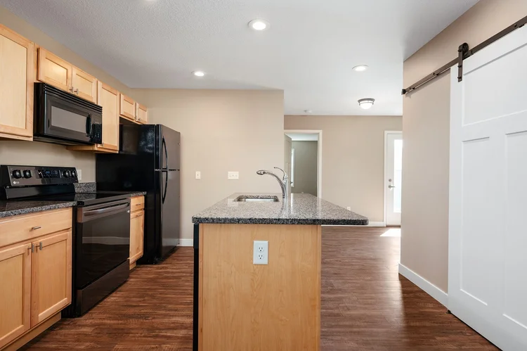 Kitchen with island, black appliances and sliding barn door