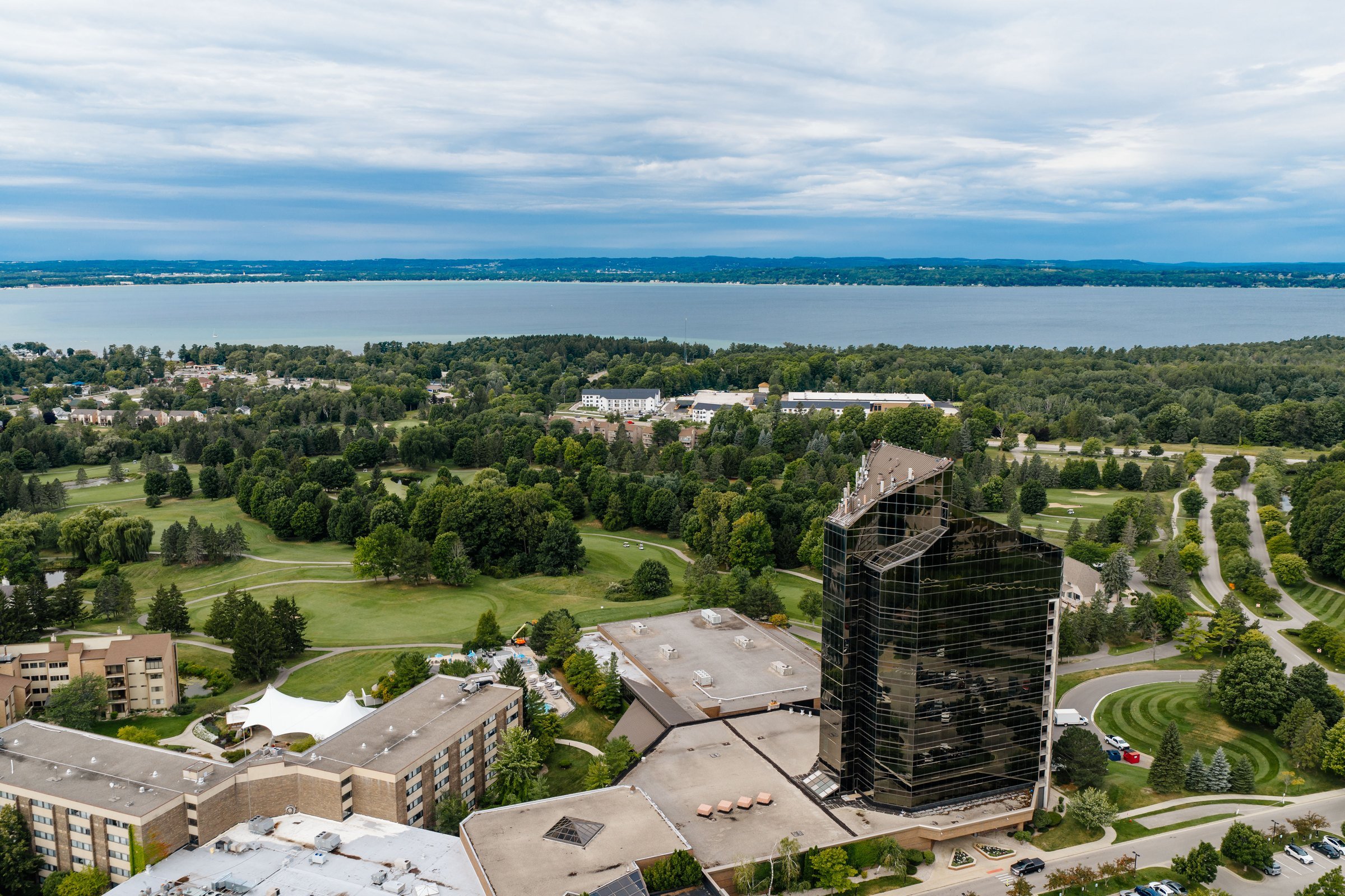 Aerial view of the Grand Traverse Resort and Spa tower and golf course with East Grand Traverse Bay behind