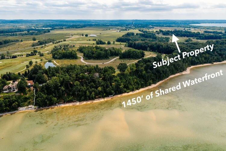 Aerial of shared waterfront with subject property arrow