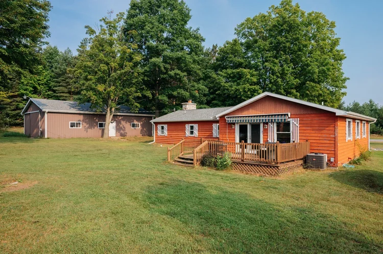Back of the house with deck and pole barn