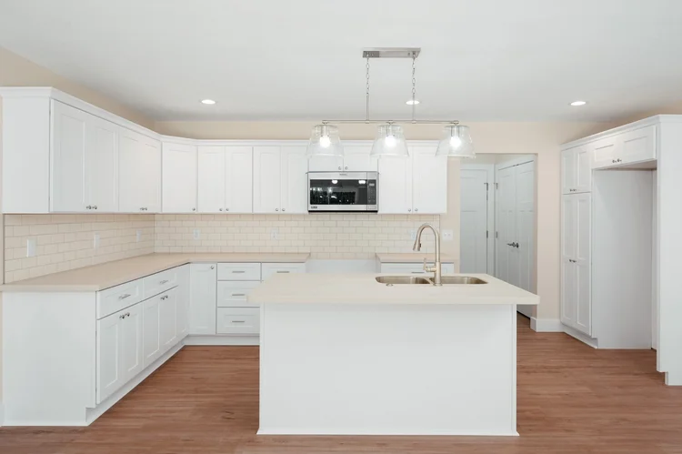 Kitchen with white cabinets and island with sink