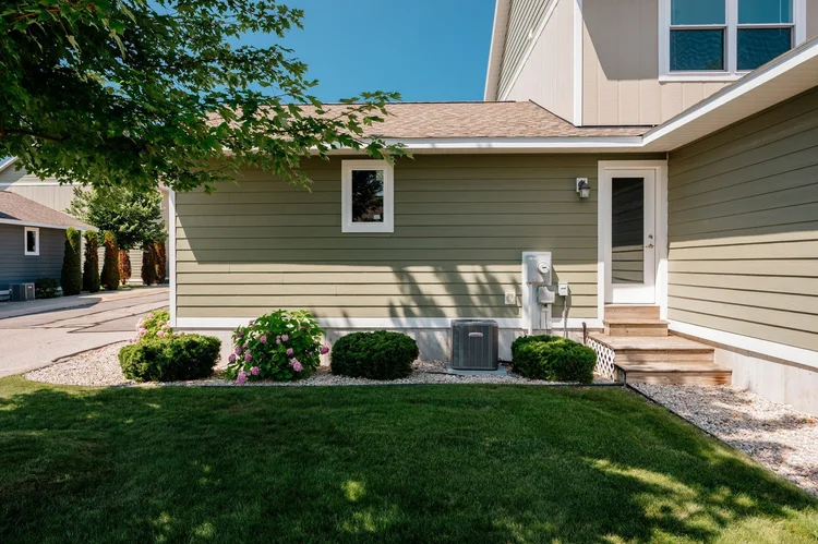 Side yard with lawn, shrubs and side entry steps