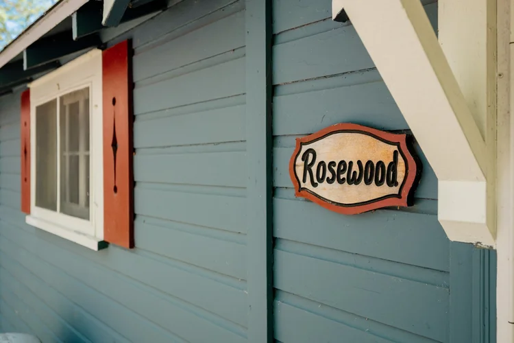 Rosewood name plaque beside a red shutter