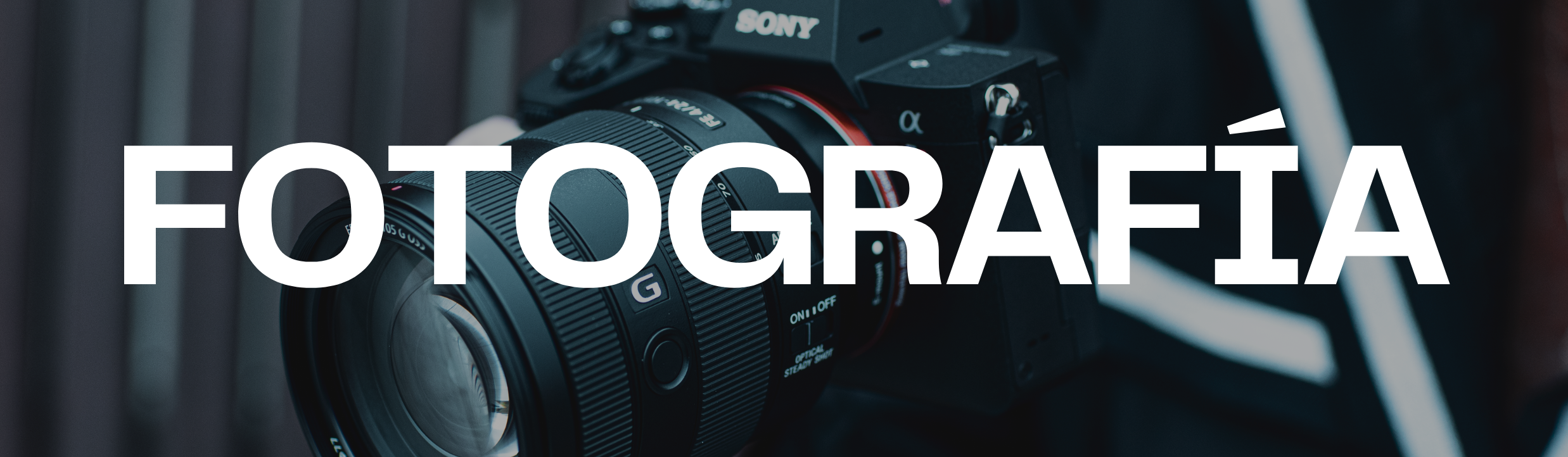 Cámara profesional de fotos en primer plano con el texto 'Fotografía' en grande sobre ella.