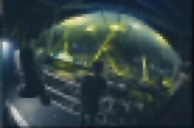 Una escena en una nave o estación de control con una estructura grande y metálica, con luces brillantes y un ambiente futurista o tecnológico.