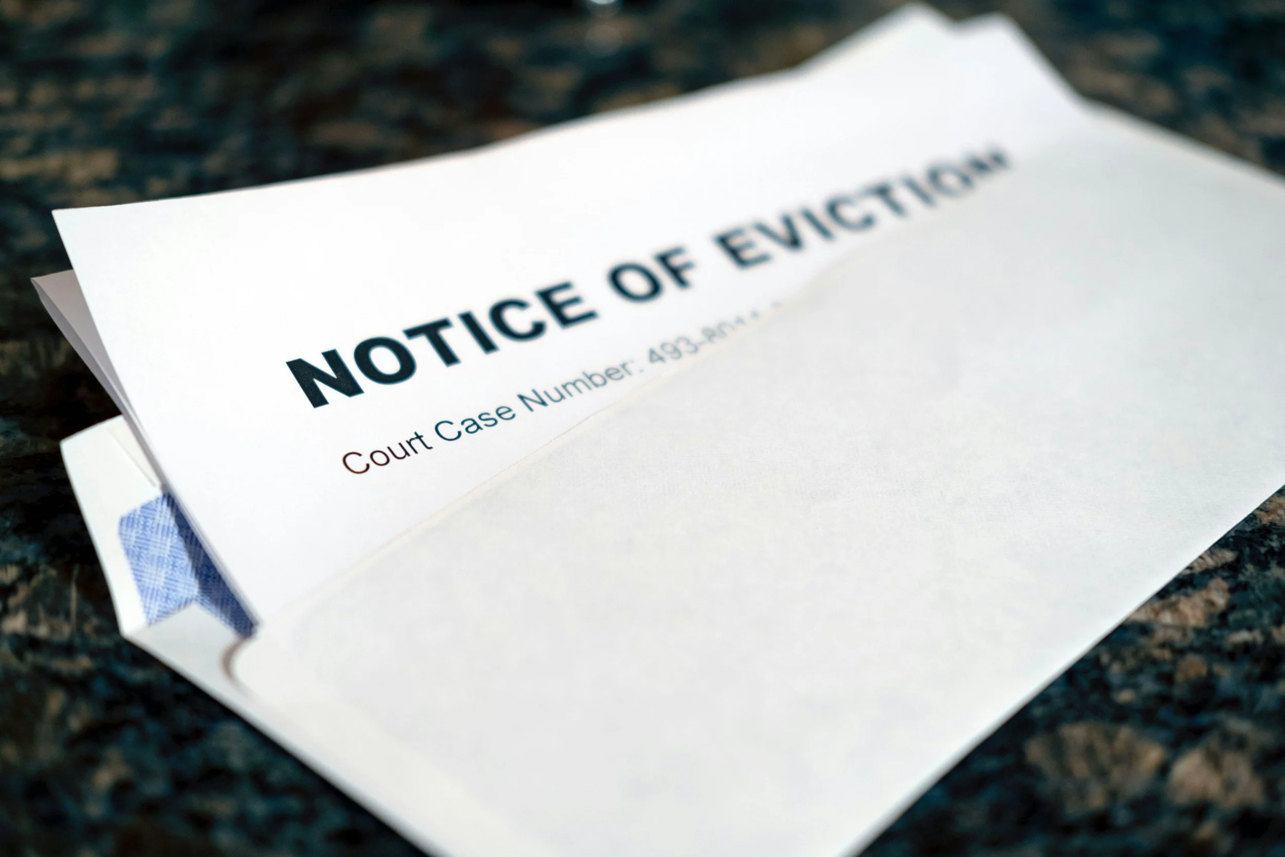 A legal notice of eviction placed on a dark surface, with the title in bold and a court case number underneath.