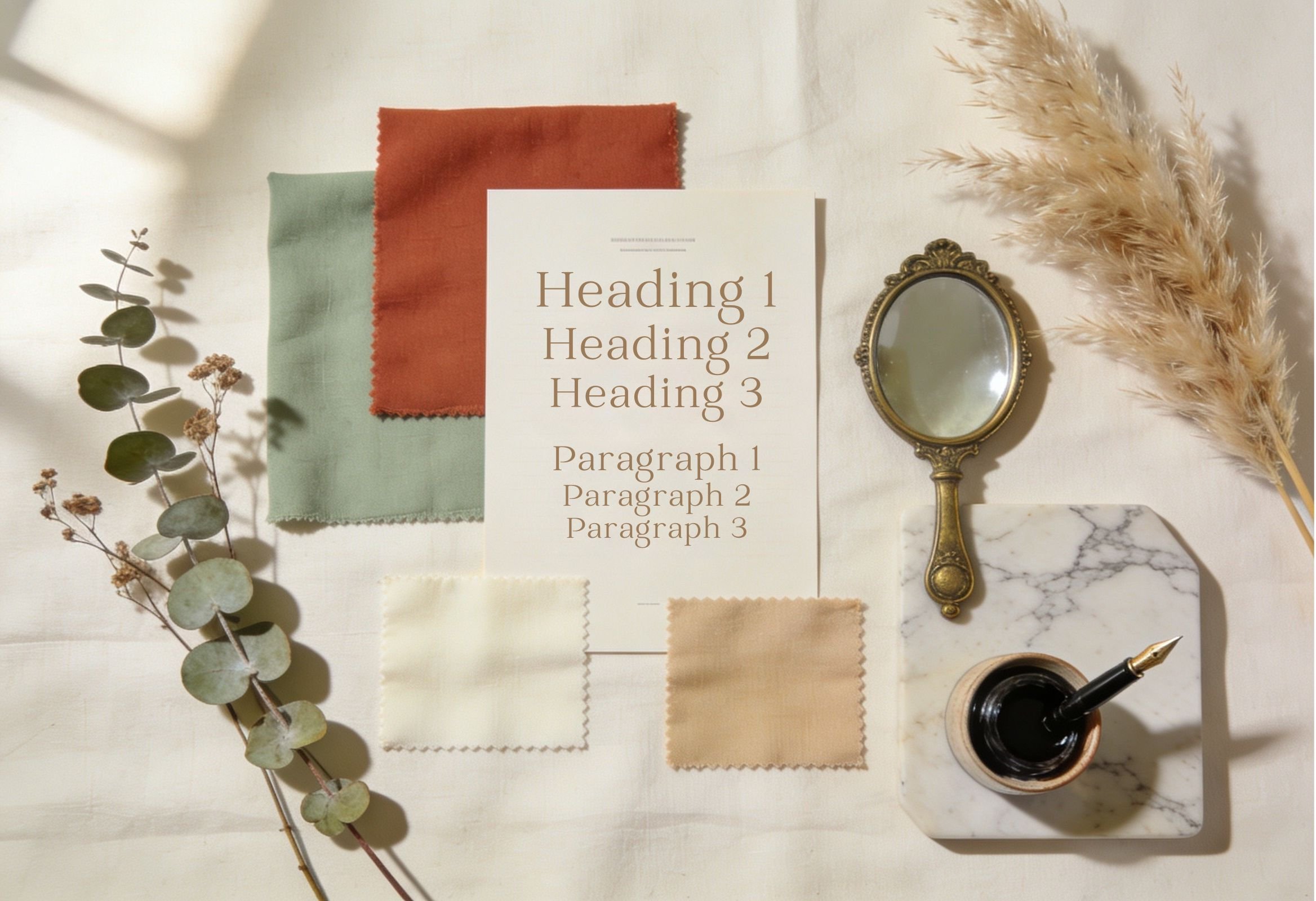 A mood board of fabric swatches, typography samples, dried eucalyptus, and a fountain pen on a cream linen surface.