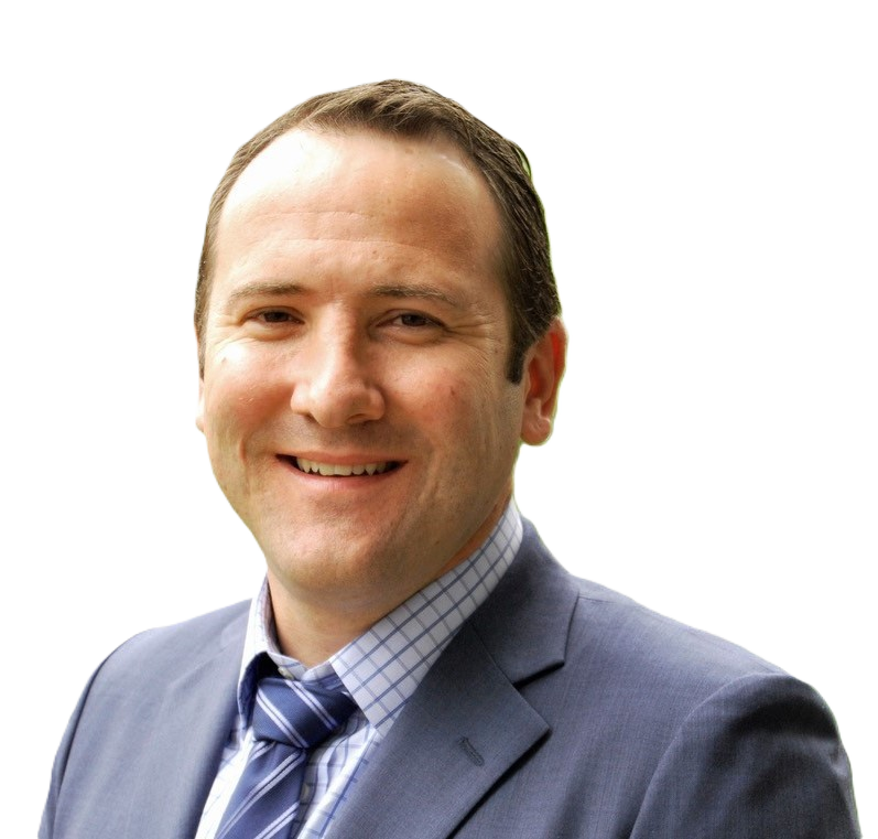 A smiling man wearing a gray suit, checkered shirt, and striped tie, with a blurred background.