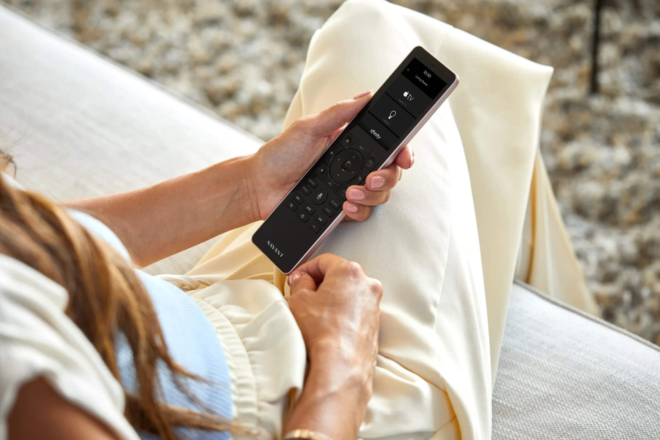 Person holding a remote control with streaming service options on a couch