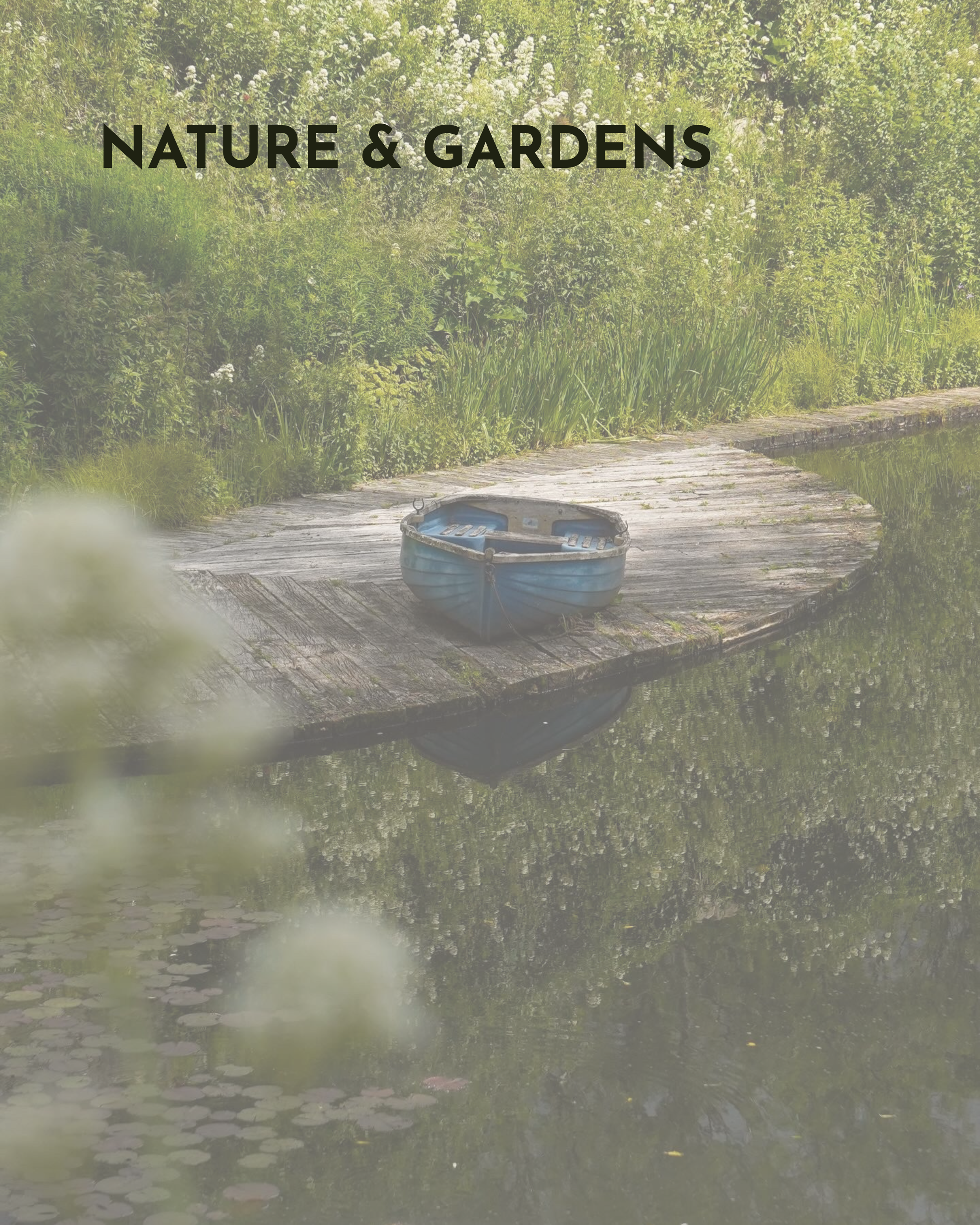 A small rowing boat on a wooden deck surrounded by lush greenery