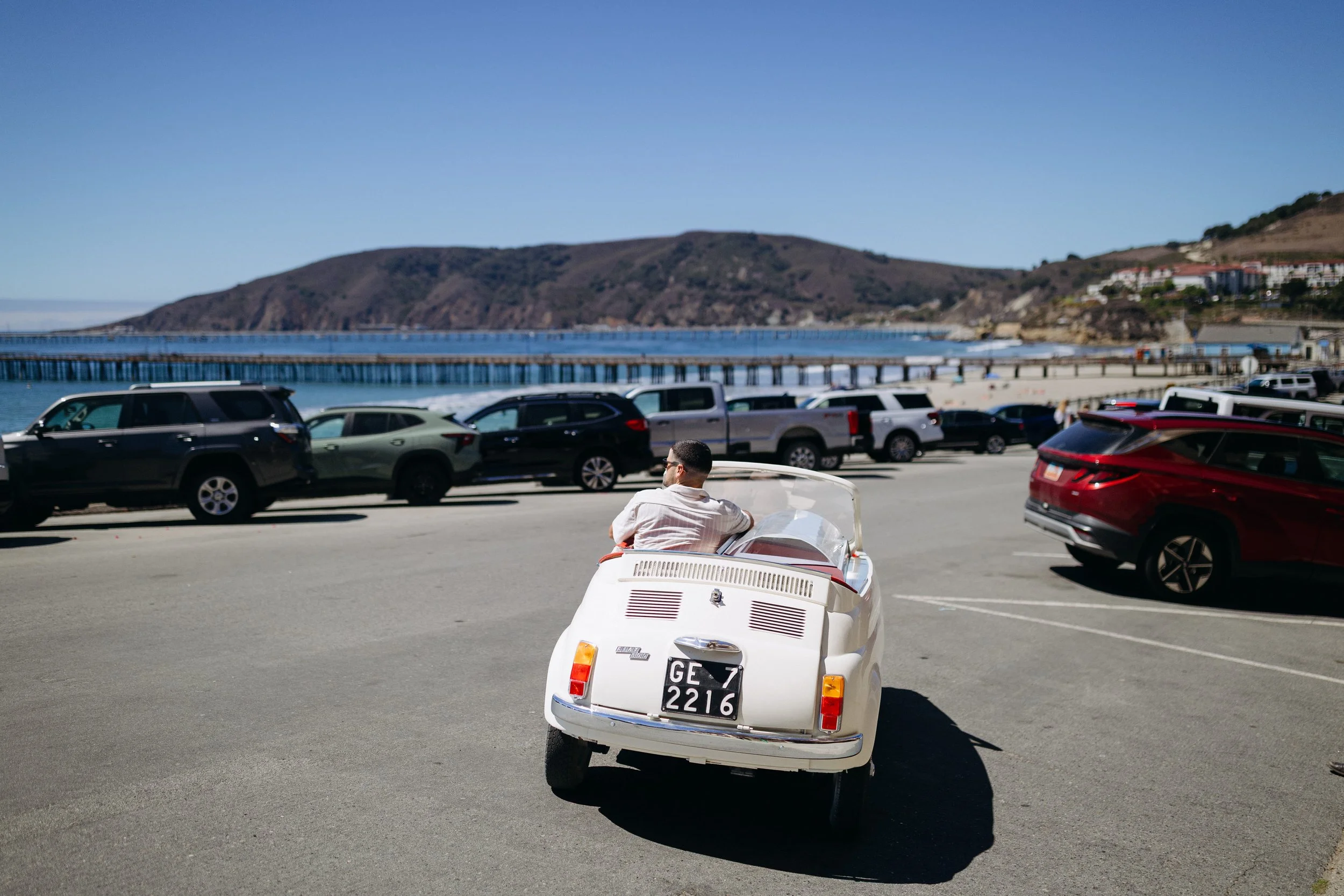 Man driving Fiat 500 convertible down the coast