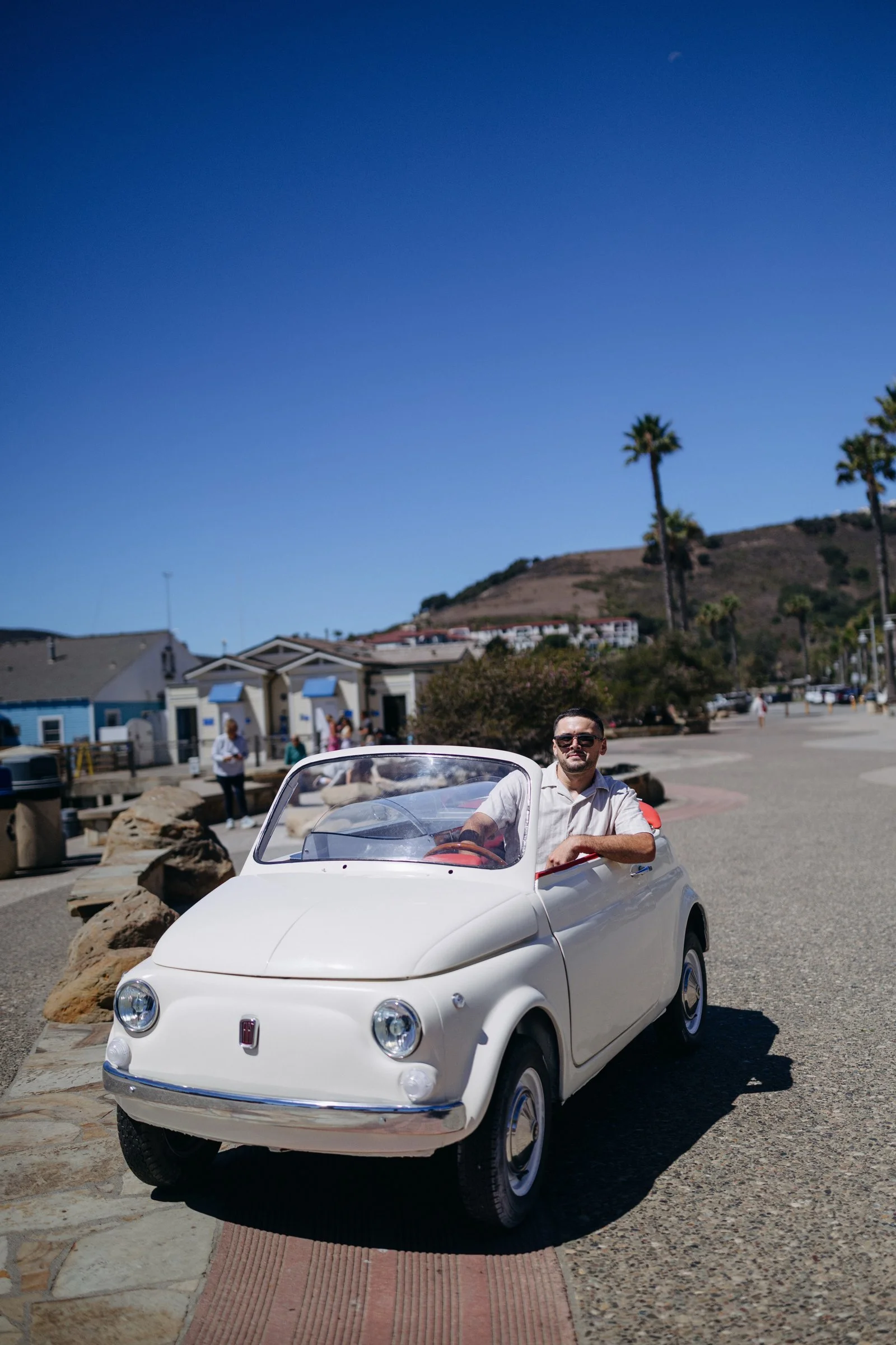 Vintage Fiat 500 convertible on a coastal promenade