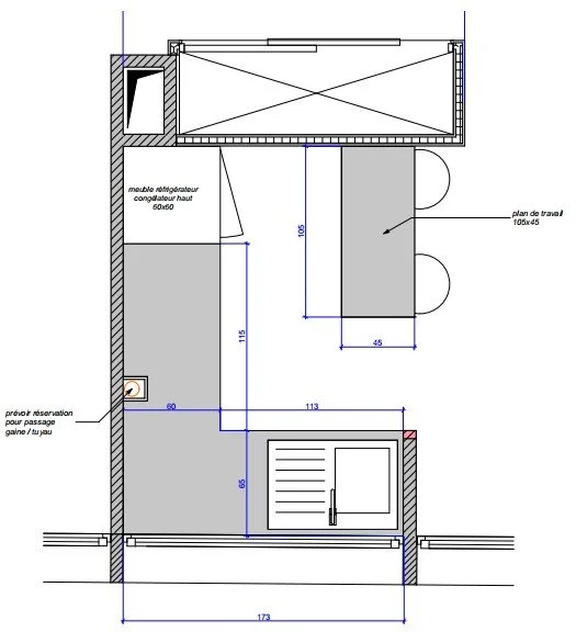 Plan d'aménagement d'une petite pièce avec des dimensions, comprenant un espace de travail avec un plan de travail, un meuble réfrigérateur, une porte, et une ouverture pour passage de gaines ou tuyaux.