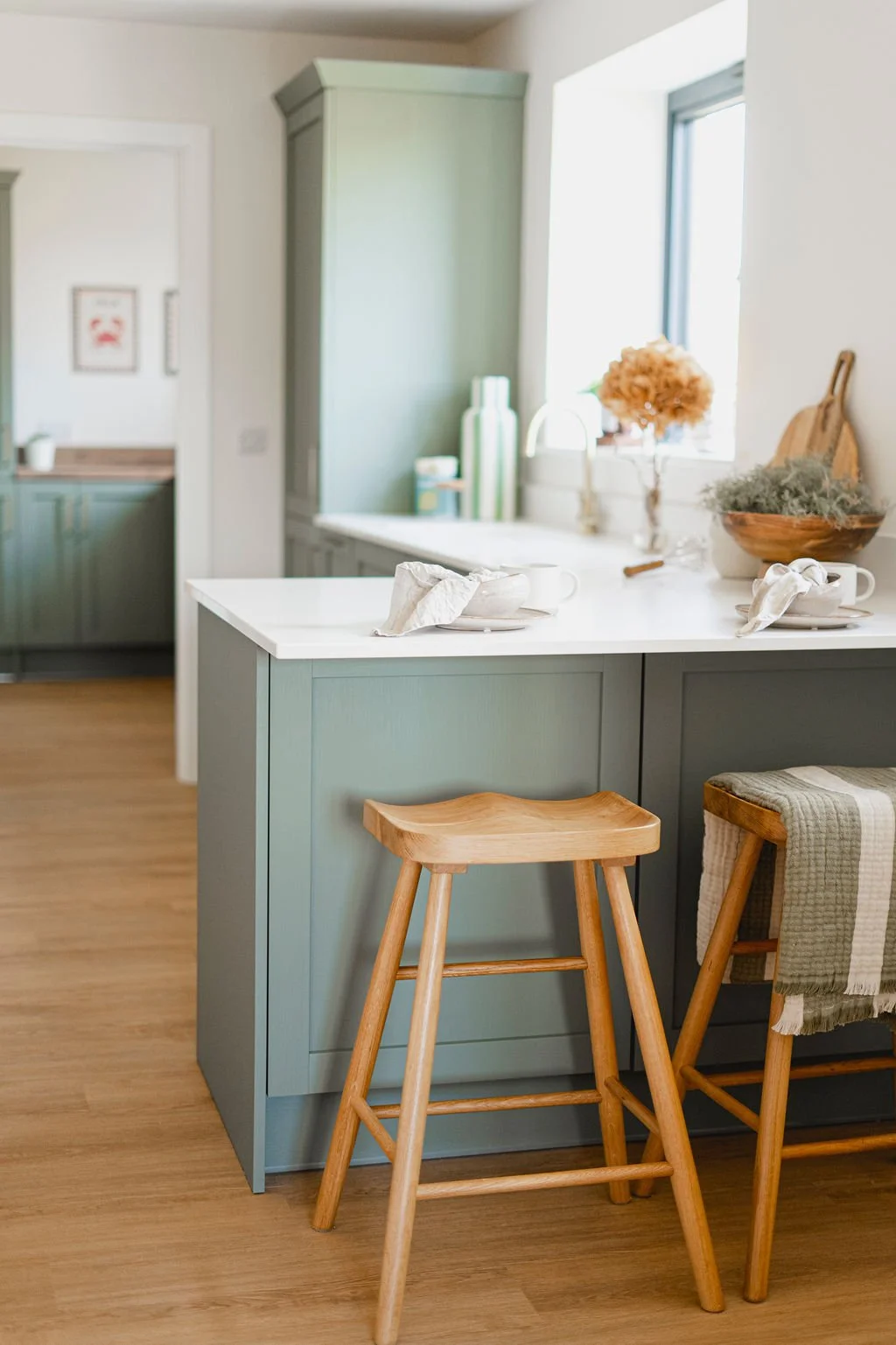 Green kitche. Breakfast bar area with 2 wooden stools