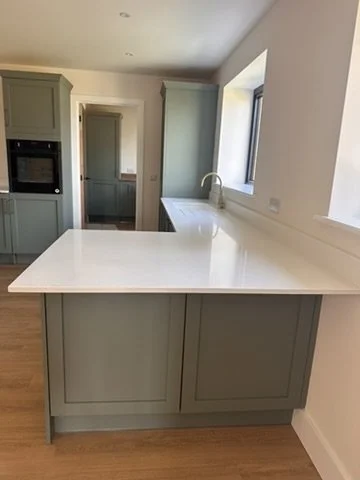 Empty green kitchen. Wooden flooring, large window