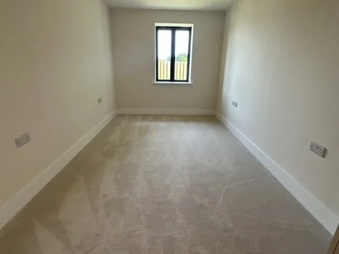 Empty room with beige carpet & large window