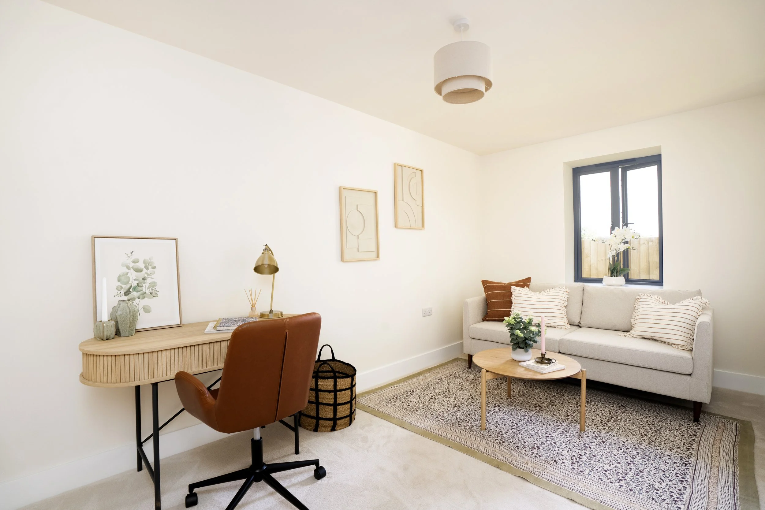 Professionally staged home office and sitting room in a Somerset property with desk, neutral sofa and warm oak furniture. brown leather chair with oak desk. Double sofa in a neutral colour with low coffee table. Large rug on floor