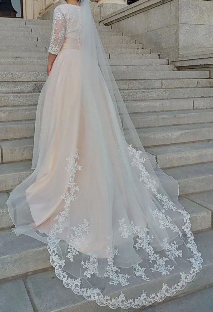 Cathedral wedding veil with floral lace edge in ivory, single tier design flowing elegantly behind bride.