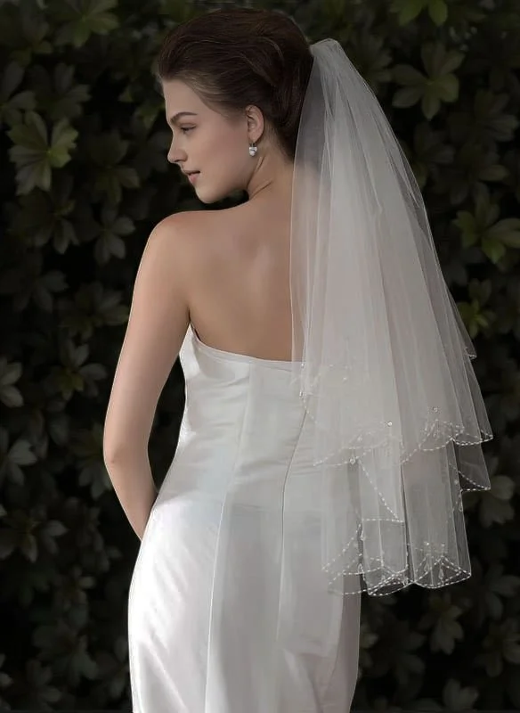 Two-tier short bridal veil with scalloped beaded edges and teardrop crystal details, sheer veil highlighting dress lace.