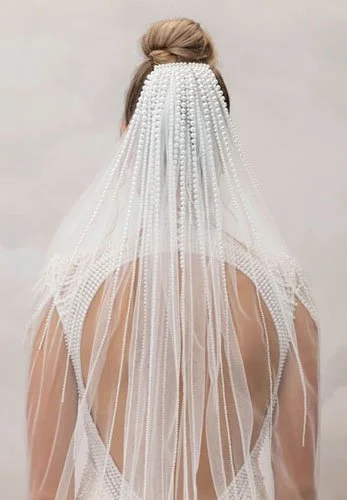 Back view of bride wearing gradient pearl placement veil, heavier at the comb and tapering down, a refined 2026 bridal veil trend.