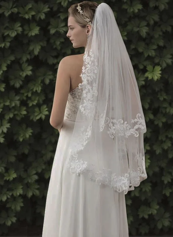 Bride wearing a two-tier fingertip veil with blusher features floral lace edges, ultra-light breathable tulle, and a flattering drape.