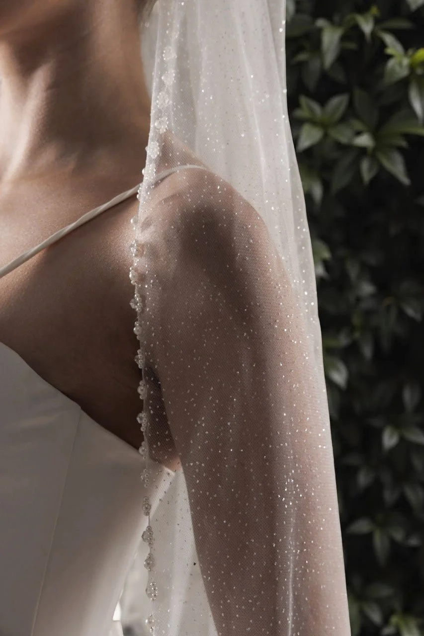 Glitter tulle fabric close-up showing delicate shimmer of wedding veil