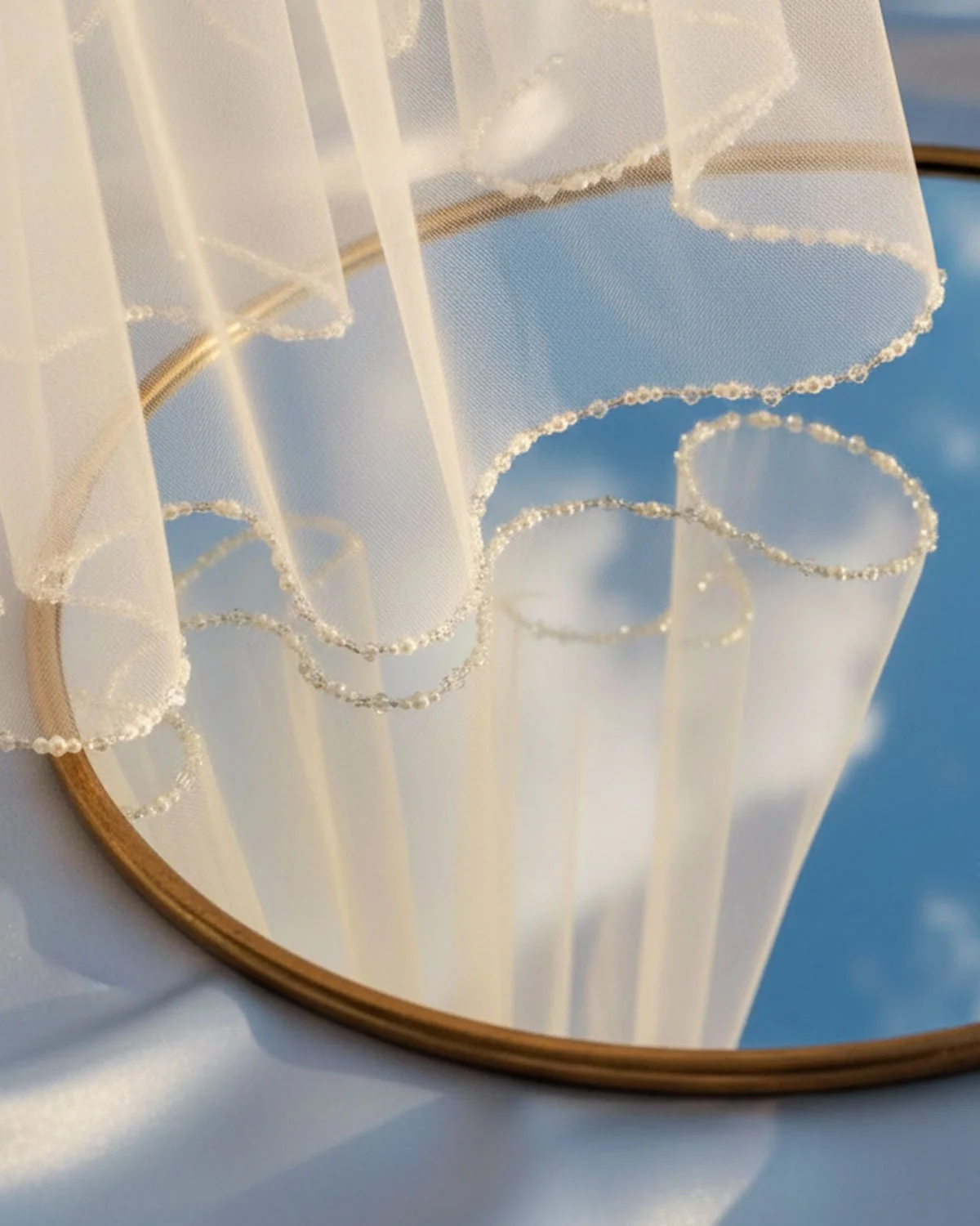 Close up detail shot of a beaded pearl edge single tier wedding veil available with custom lengths in off-white, ivory and champagne tulle.