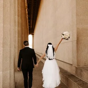 Bride wearing a short shoulder length ribbon bow wedding veil in ruffle white wedding dress.