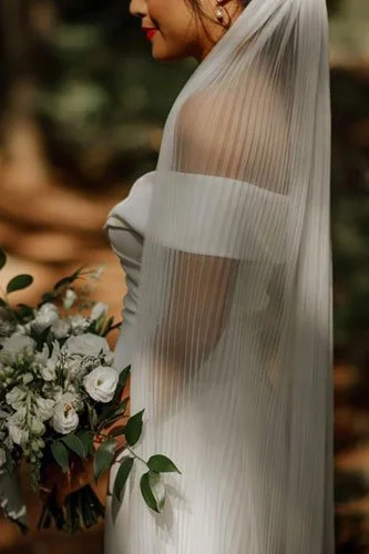 Bride wearing pleated wedding veil, highlighting the latest 2026 wedding veil styles with texture and movement.