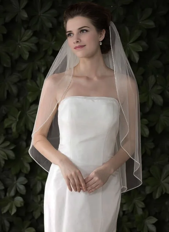 Bride wearing fingertip length beaded edge single tier bridal veil with sequin diamanté trim and soft straight drape.