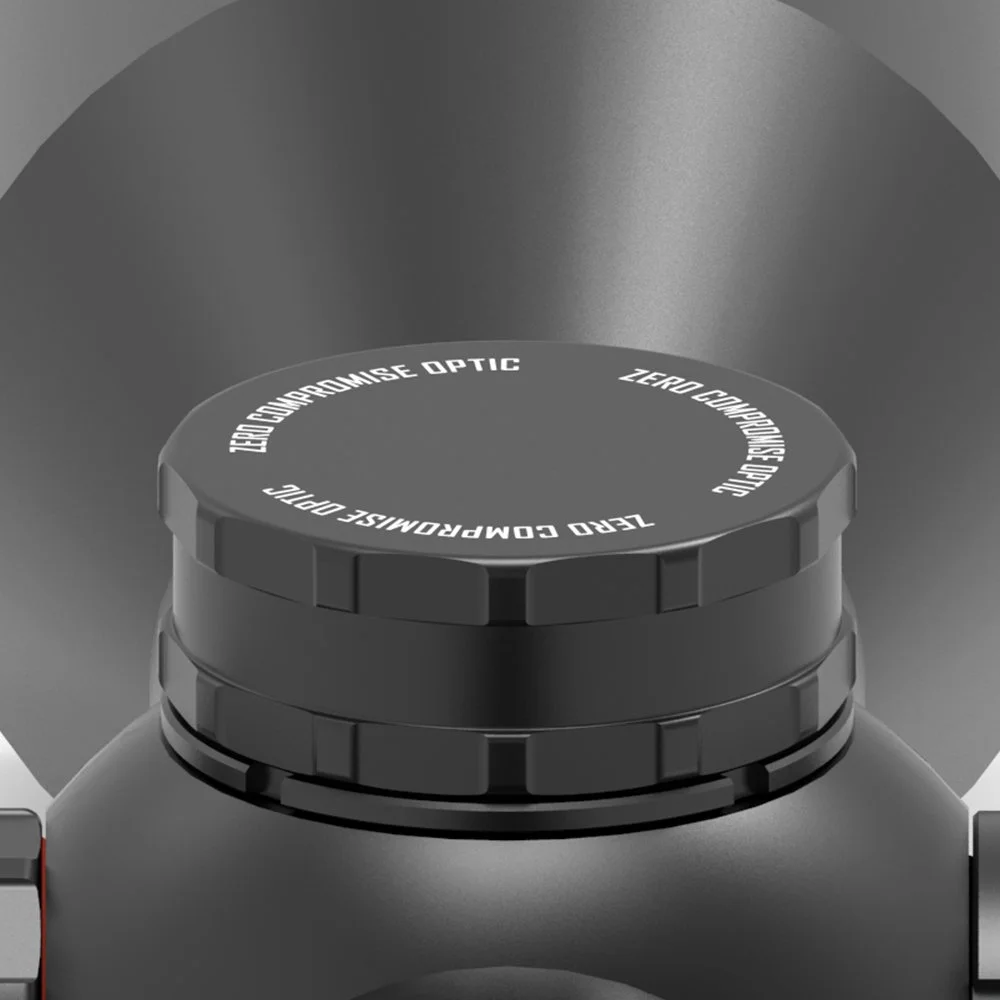 Nahaufnahme eines schwarzen Objektivs mit weißer Schrift, dass 'Zero Compensation Optic' und 'Zero Compensate Optical' sagt, auf einer grauen Oberfläche.