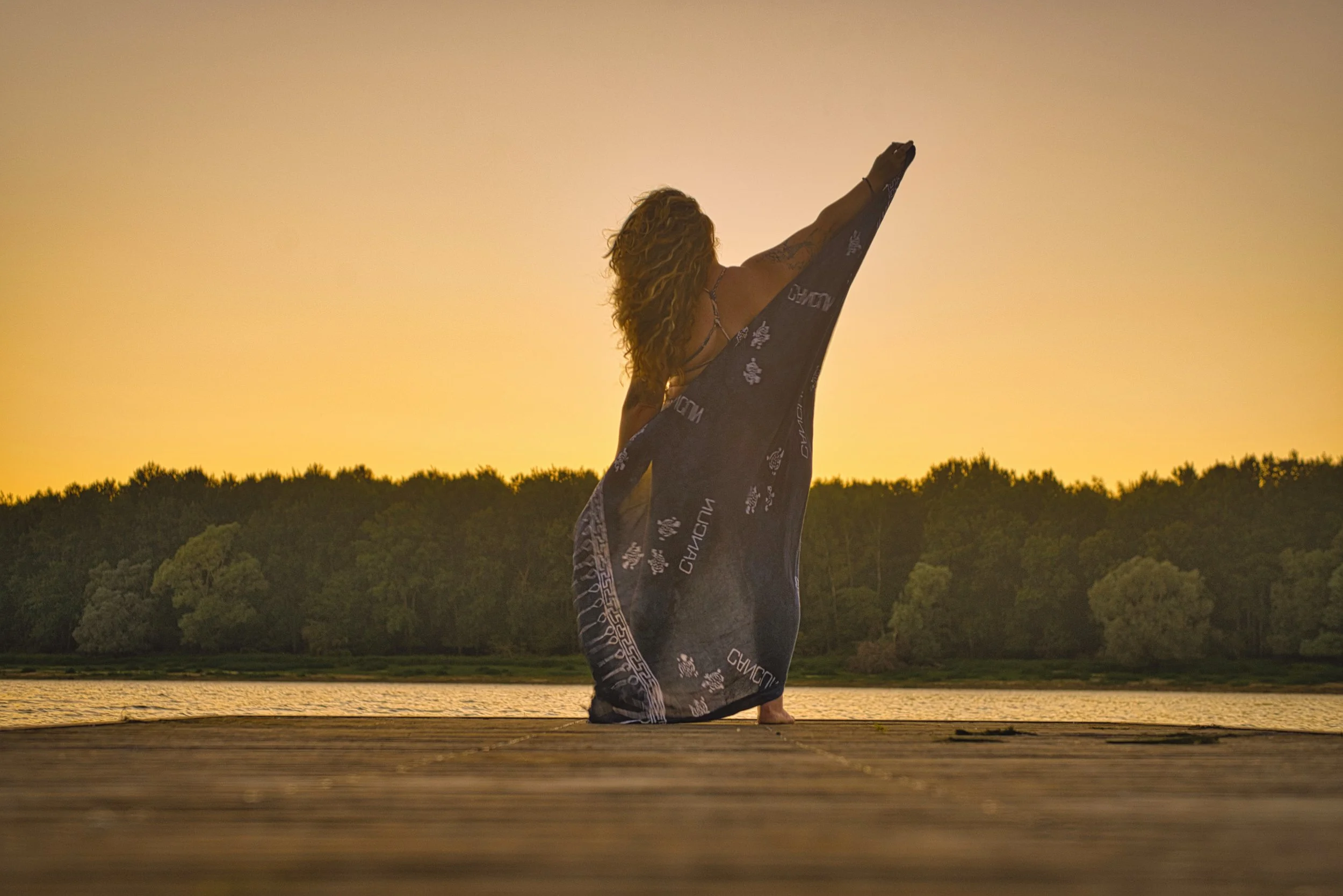 femme au bord de l'eau sur un pont en robe bleu