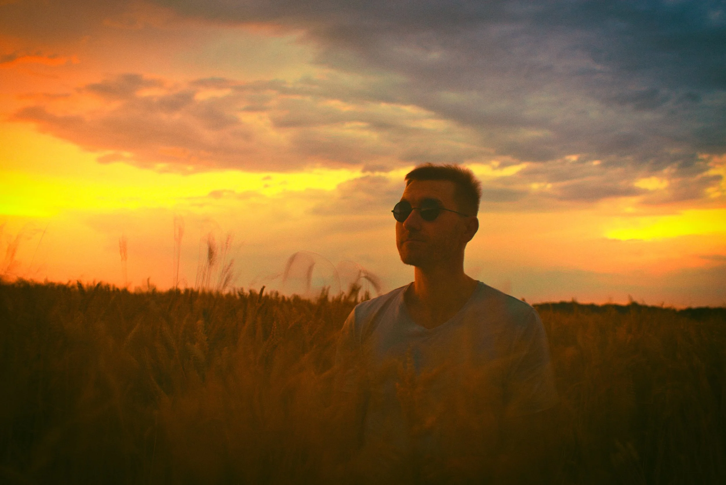 Portrait d'un homme au look rétro dans les champs de Radonvilliers avec un magnifique ciel au coucher du soleil.