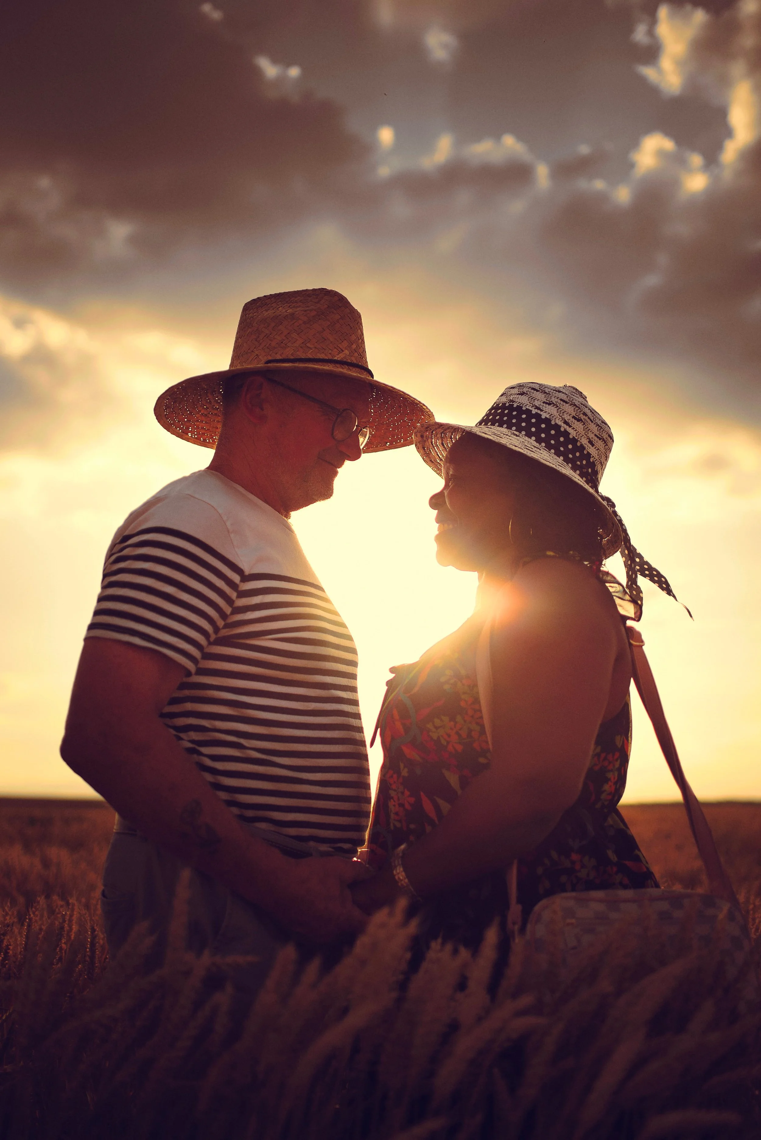 portrait d'un couple dans un champ de blé au coucher du soleil