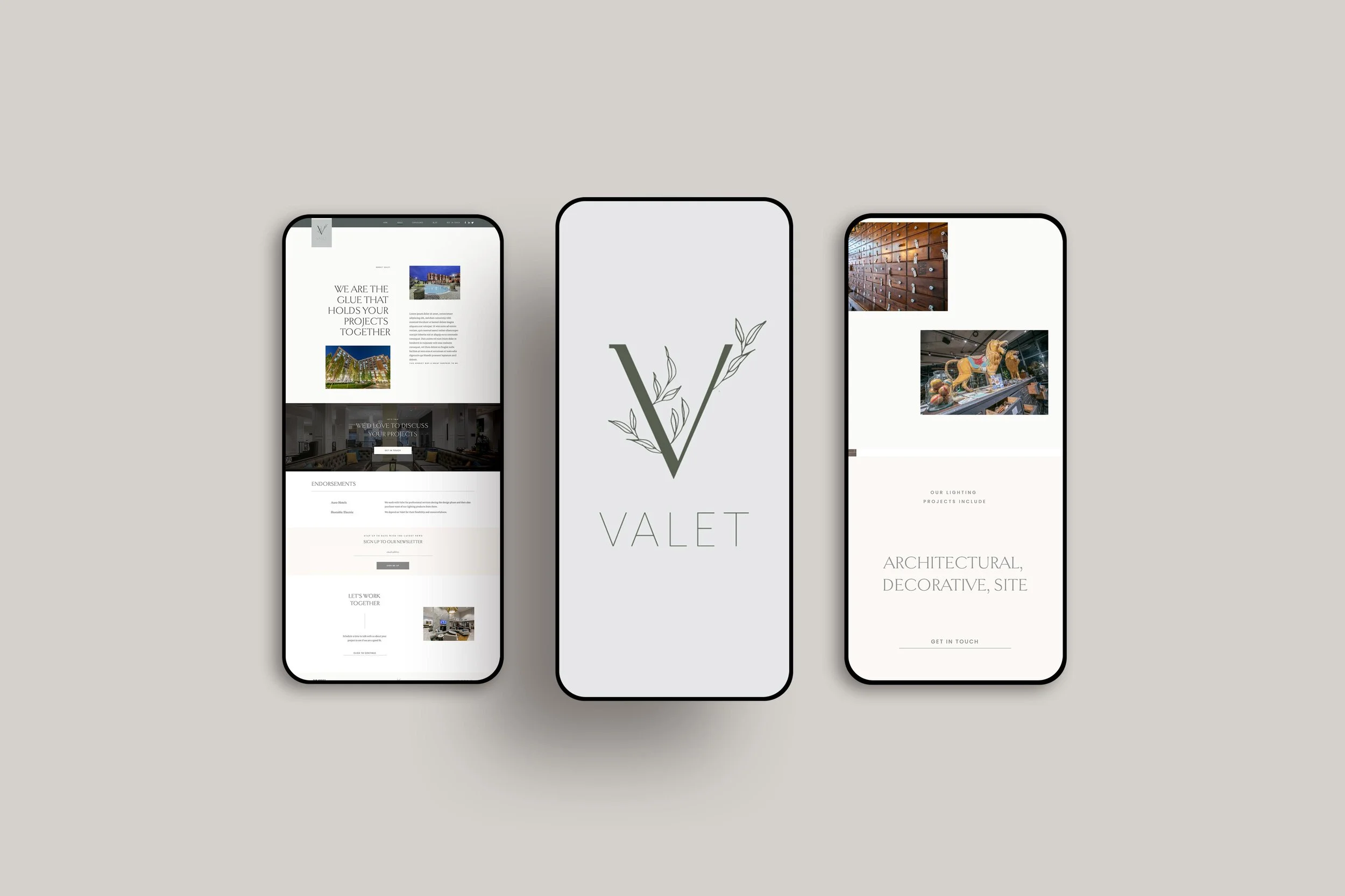 Three smartphones displaying a website design for an interior design or architecture company. The central phone shows the logo with a green 'V' and leaf design with the name 'VALET'. The left phone displays a web page with images of buildings and text about projects and endorsements. The right phone shows images of a wooden wall and decorative sculptures with text about lighting and site projects.