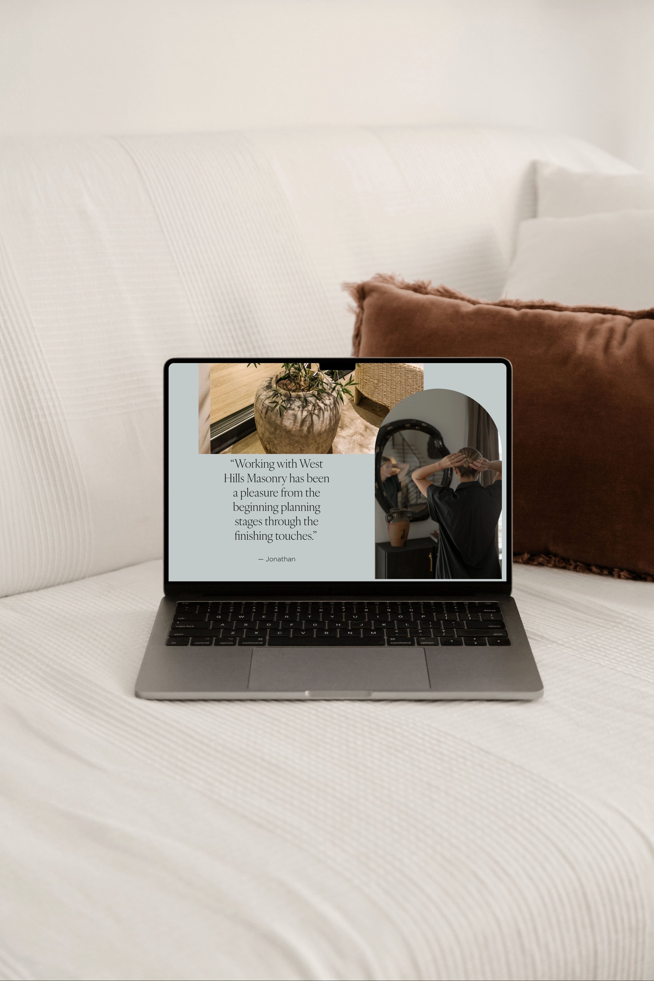 Close-up of a laptop on a white textured surface with a blurred background showing a brown pillow and part of a white sofa.