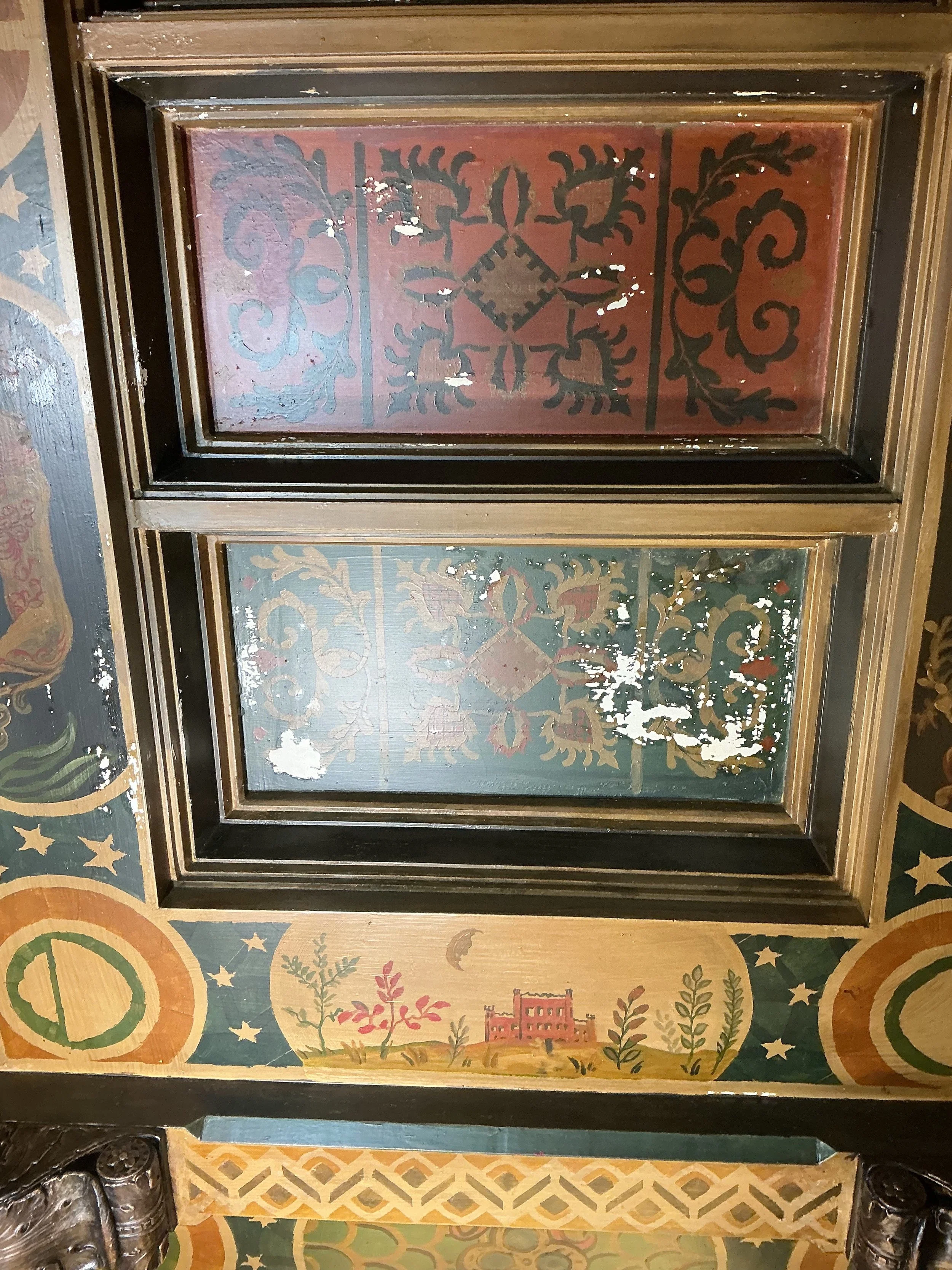 Decorative painted panels with black scrollwork and a central geometric design, framed in wood, with colorful patterned floor tiles around them.