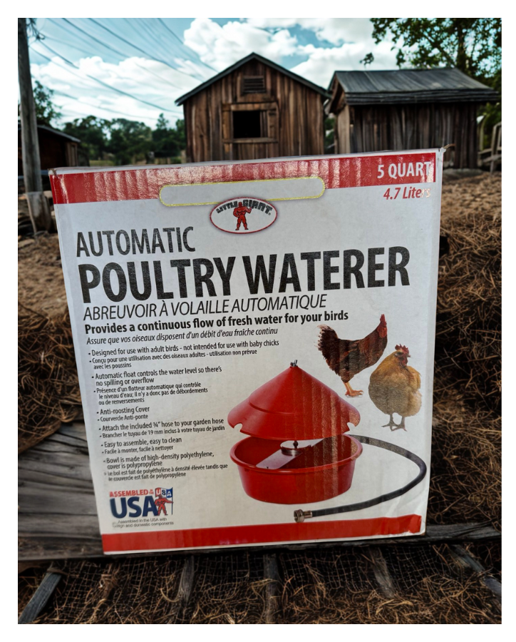 Box of automatic poultry waterer with images of a chicken and a duck, set outdoors in front of rustic wooden buildings.