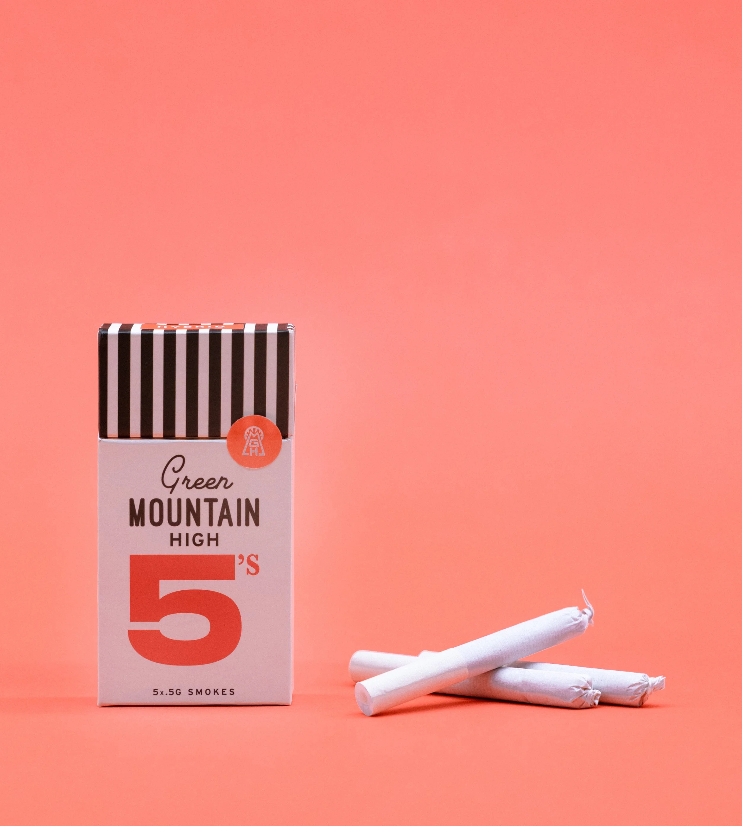 A cigarette pack labeled 'Green Mountain High 5's' with five individually wrapped cigarettes beside it, set against a pink background.