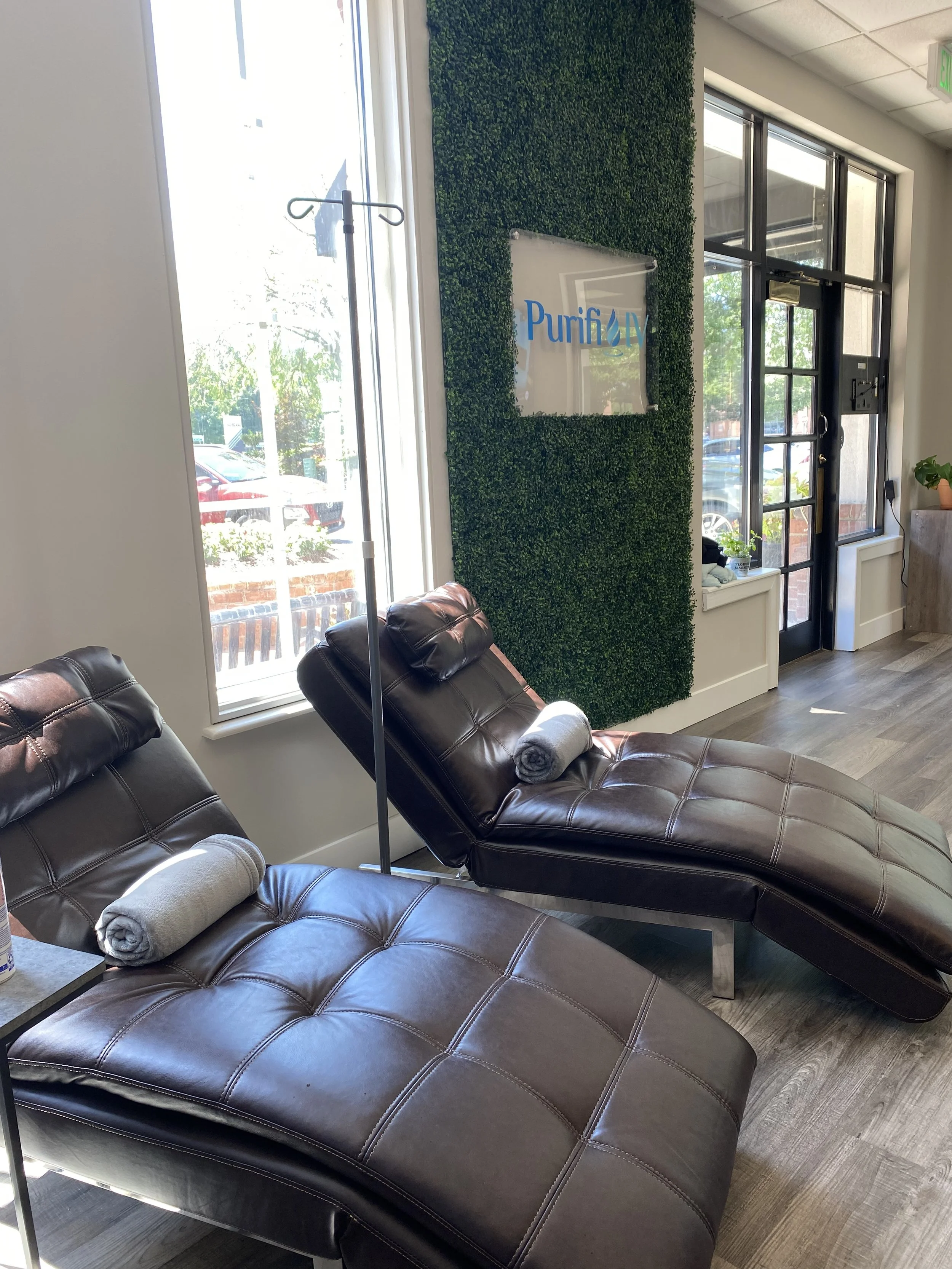 Lounge chairs in a modern, well-lit room with greenery wall.
