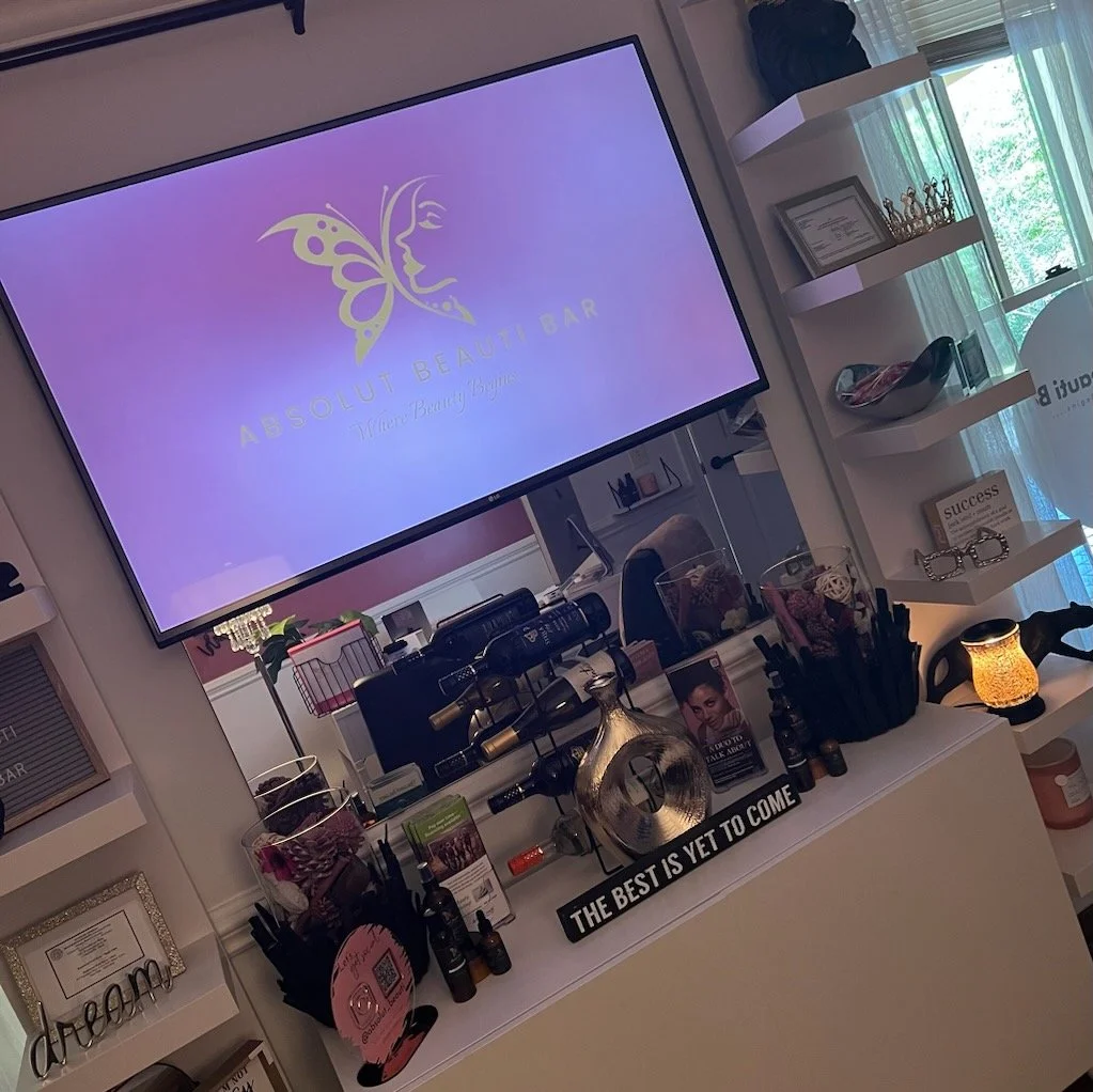 Interior of a beauty salon with products, decor, and a display screen.