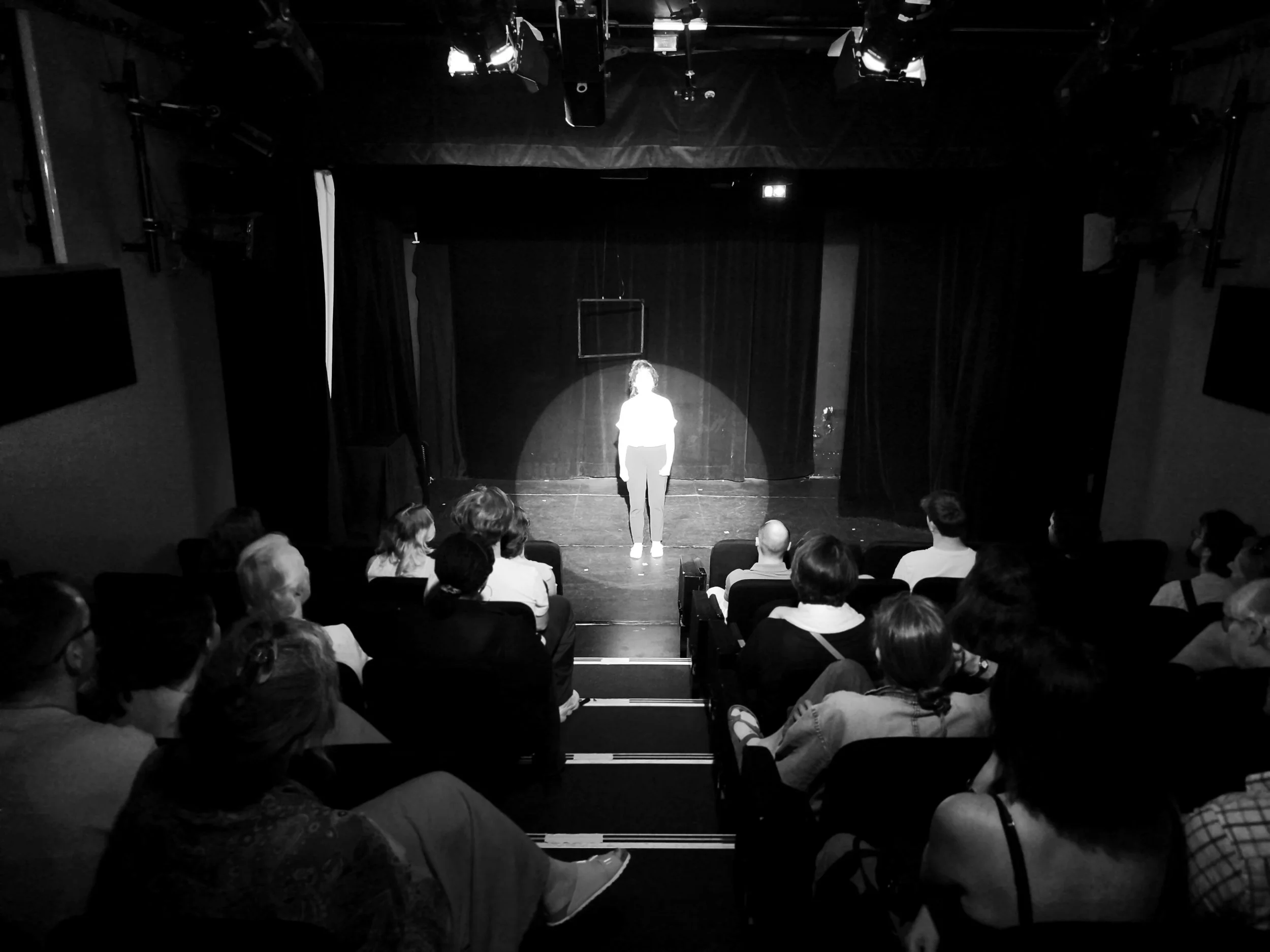 Présentation sur scène devant le public dans le cadre d’un atelier de théâtre pour adultes à Paris.